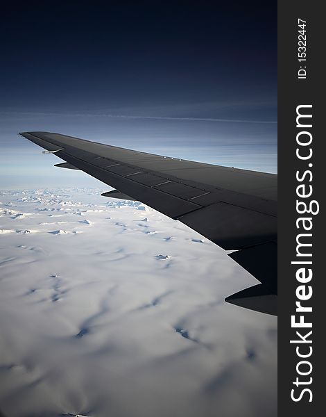 Left wing over Greenland on the dark sky