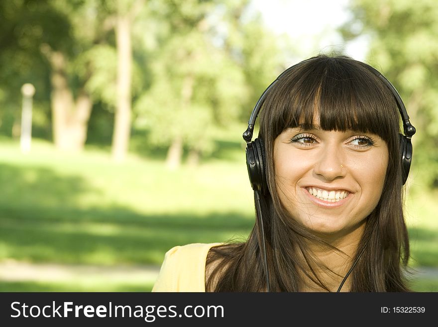 Smiling young woman listening to music at park