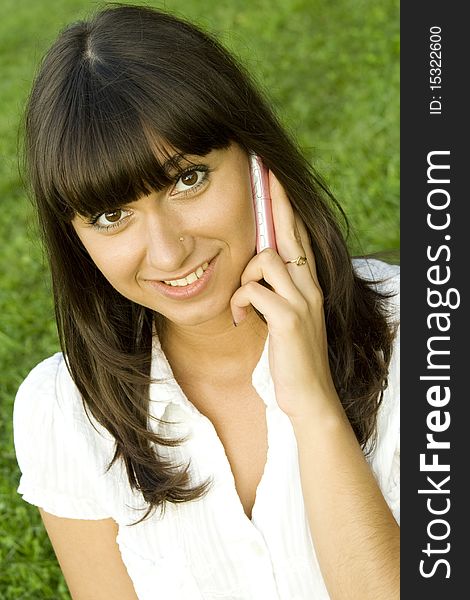 Young beautiful woman on the phone in the park. Young beautiful woman on the phone in the park.