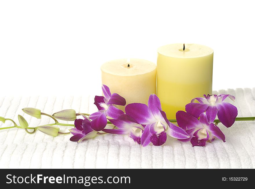 A beautiful orchid, towel and candles. A beautiful orchid, towel and candles