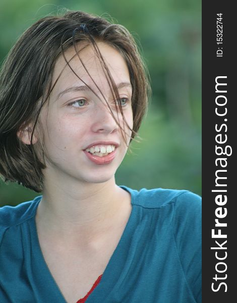 A young teen with windblown hair stares off in the distance