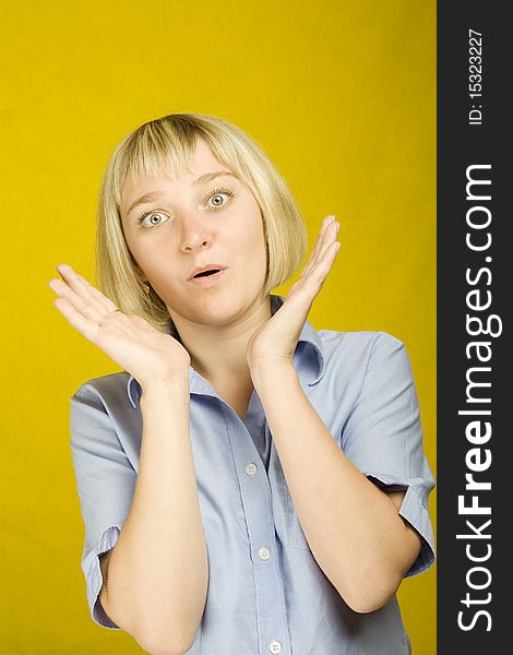 Young woman expressing emotions on a yellow background