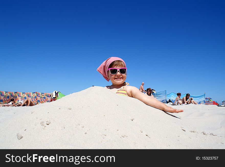 Little girl in pink glasses, sitting on the beach. Little girl in pink glasses, sitting on the beach