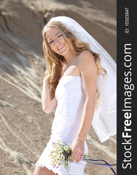 Happy bride in her white dress on a windy summer day