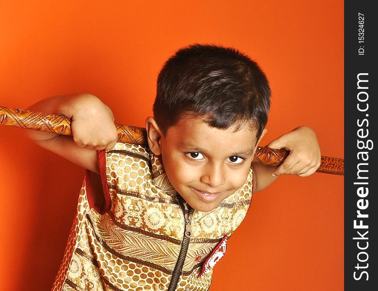 A mischievous boy from an Indian village posing with a wooden club. A mischievous boy from an Indian village posing with a wooden club.