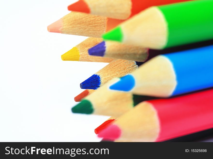 Close up of color pencils with different color over white background.