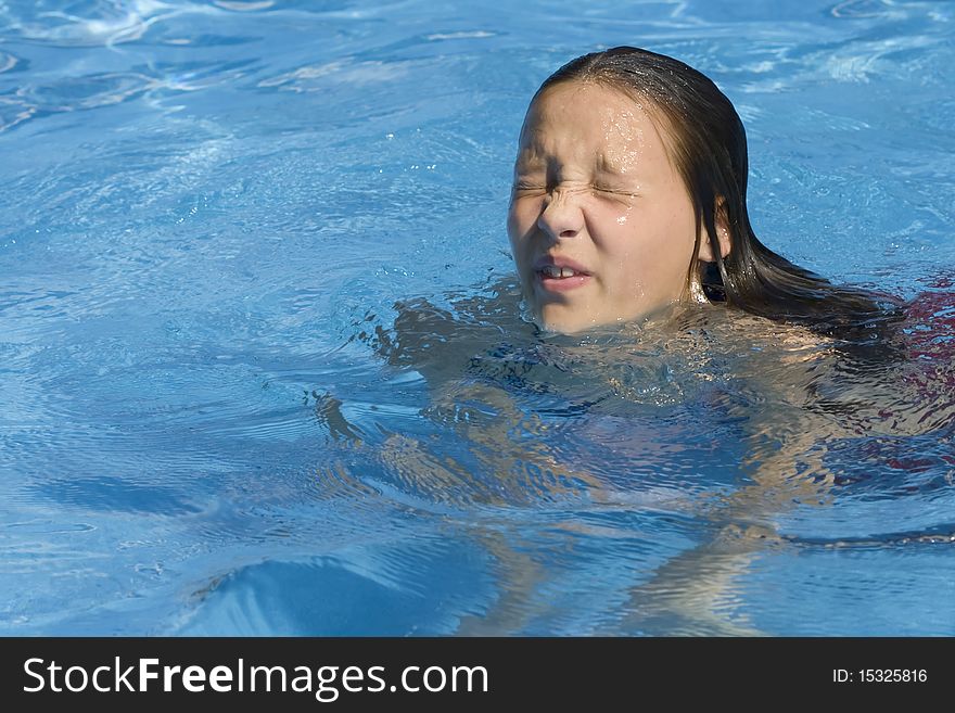 Young girl with water in her eyes, swimming in pool. Young girl with water in her eyes, swimming in pool.