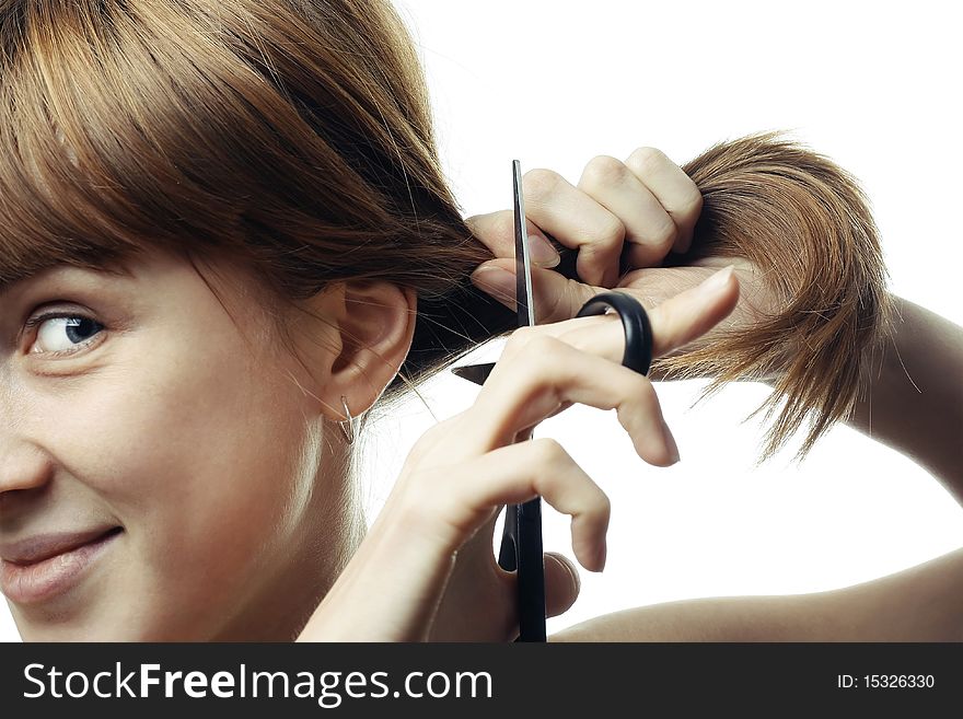 Young smiling woman with scissors going to cut her hair