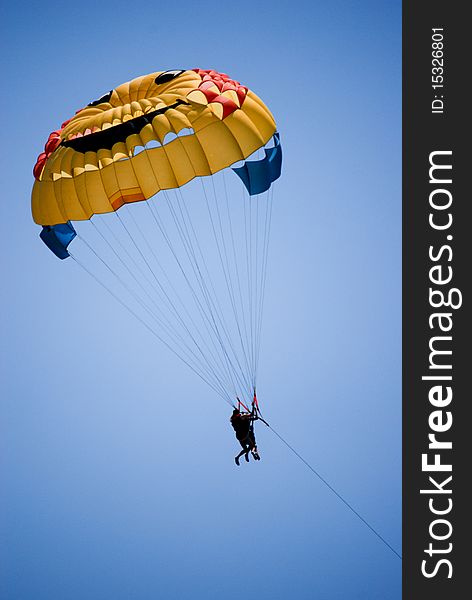 Man parasailing above Mediterranean sea.