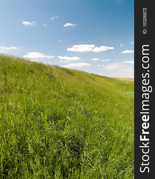 Green field blue sky with clouds