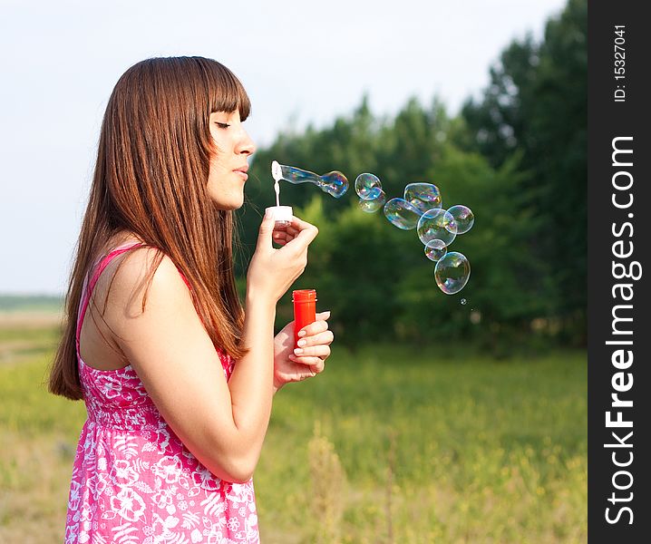 Girl blowing bubbles of soap in sunny weather. Girl blowing bubbles of soap in sunny weather