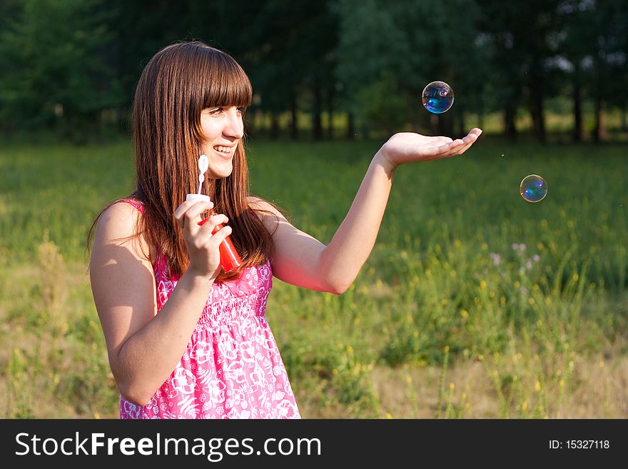 Girl blowing bubbles of soap in sunny weather. Girl blowing bubbles of soap in sunny weather