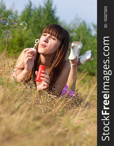 Girl blowing bubbles of soap in sunny weather. Girl blowing bubbles of soap in sunny weather