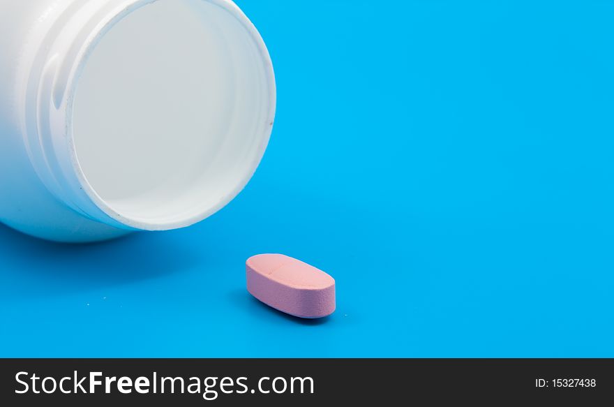 Pills from the medical can on blue background. Pills from the medical can on blue background.