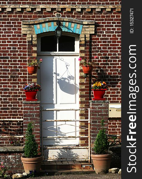 House details with flower pots, shadows on the door and wall. House details with flower pots, shadows on the door and wall