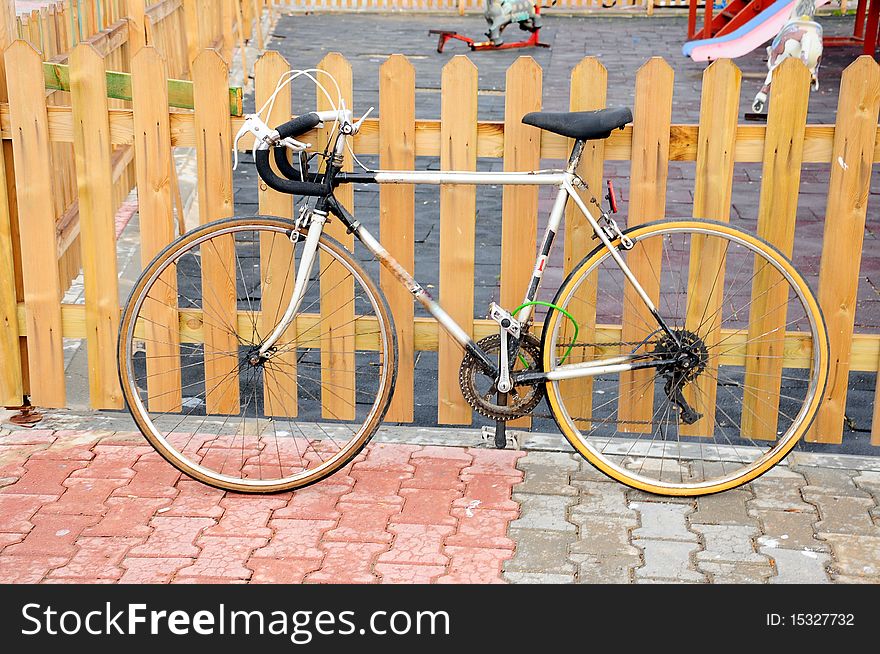 Bike on pavement by wooden fence