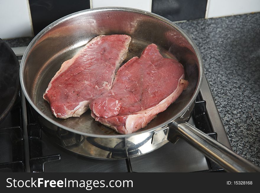 Frying two large Steaks in the frying pan. Frying two large Steaks in the frying pan
