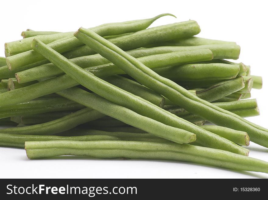 Fresh Long Green Beans, isolated on a white background table, lit with a large light source from the above right.