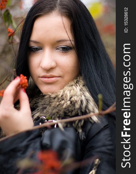 Portrai of beautiful smiling young girl with mountain ash in fall park. Portrai of beautiful smiling young girl with mountain ash in fall park