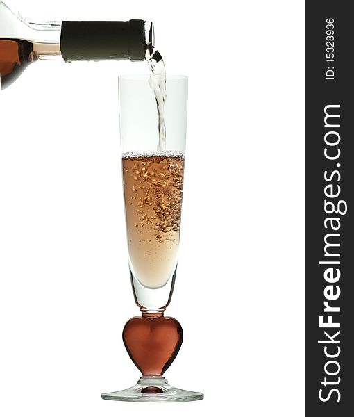 Pouring rose wine into a glass with a red, heart shaped stem