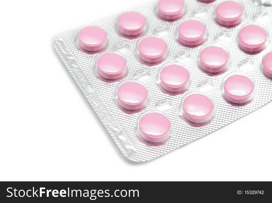 Pink pills on white background