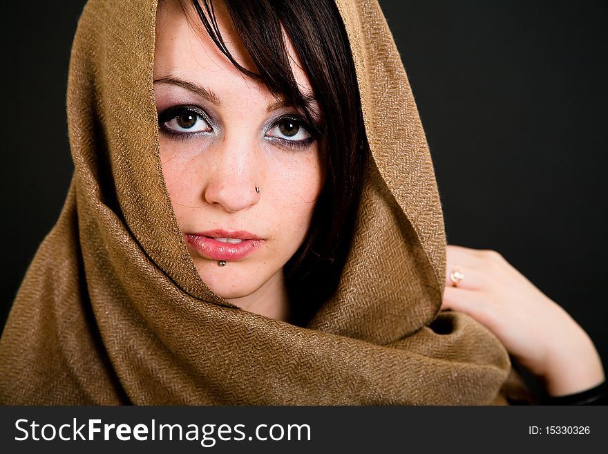 Beautiful teen girl with piercings over dark background