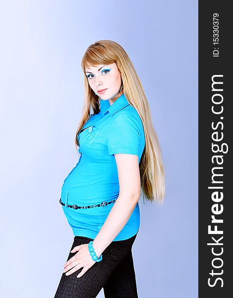 Portrait of pregnant woman with flower posing against grey background. Portrait of pregnant woman with flower posing against grey background.
