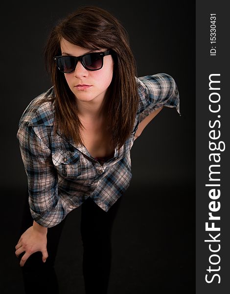 Beautiful teen girl with her sunglasses over dark background