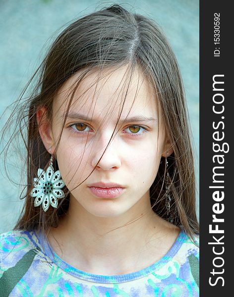 Closeup portrait of a beautiful teenage girl with long hair and earrings. Closeup portrait of a beautiful teenage girl with long hair and earrings