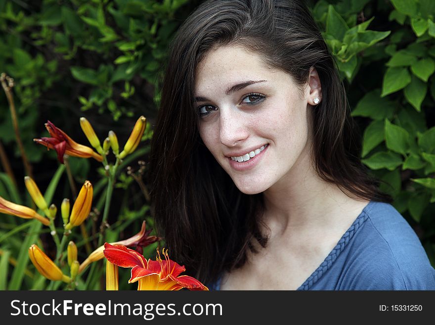 Woman holding flower and smiling in a nature area. Woman holding flower and smiling in a nature area