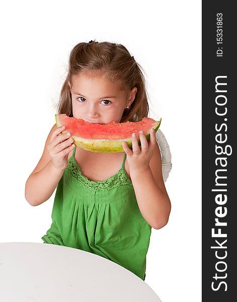 Pretty little 5 year old girl wearing a green dress and eating a watermelon. Pretty little 5 year old girl wearing a green dress and eating a watermelon.