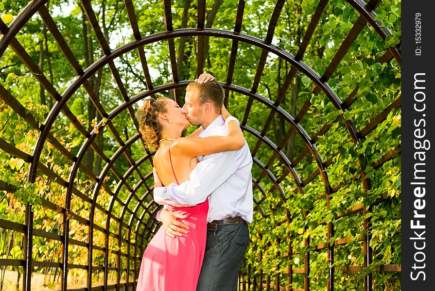 Portrait of young loving couple couple kissing in park. Portrait of young loving couple couple kissing in park