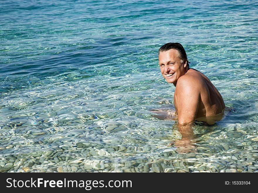 A color portrait photo of a happy smiling man in his forties relaxing in the beautiful blue sea. A color portrait photo of a happy smiling man in his forties relaxing in the beautiful blue sea.