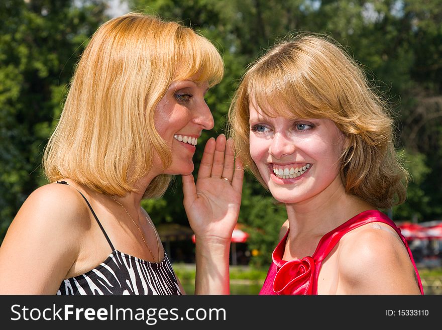 Two gossiping girls outside.