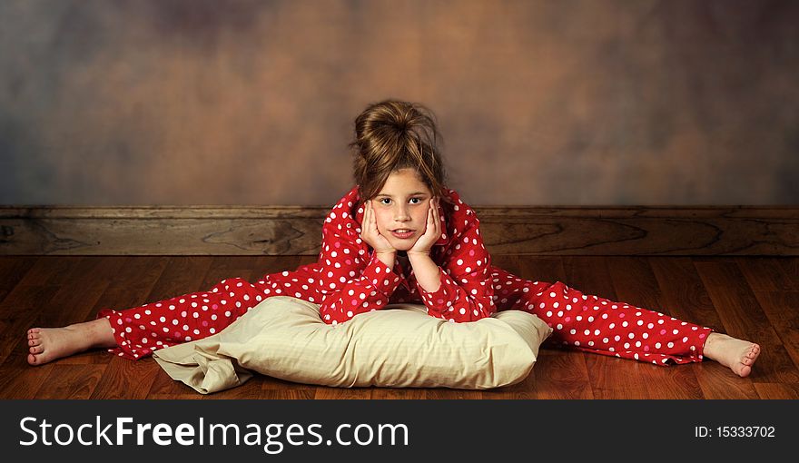 A pretty preteen with her pillow doing splits in poka-dot pajamas. A pretty preteen with her pillow doing splits in poka-dot pajamas.