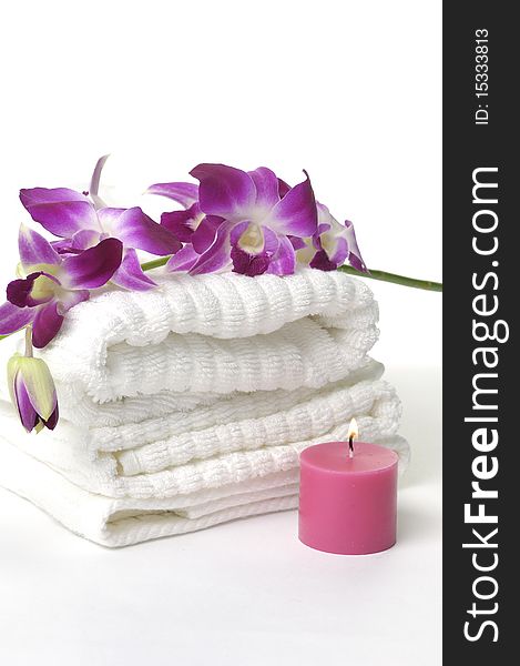 A beautiful orchid, towel and candles. A beautiful orchid, towel and candles