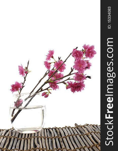 Cherry blossoms in vase on bamboo mat. Cherry blossoms in vase on bamboo mat