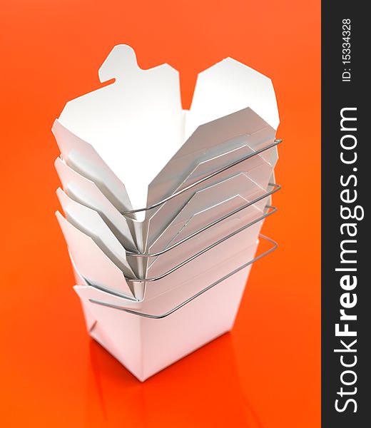 A Chinese takeaway container isolated against an orange background. A Chinese takeaway container isolated against an orange background