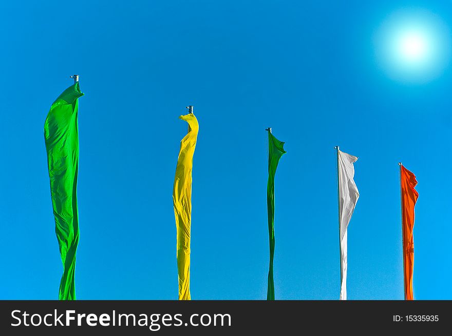 Colored windy flags on flagpoles. Colored windy flags on flagpoles