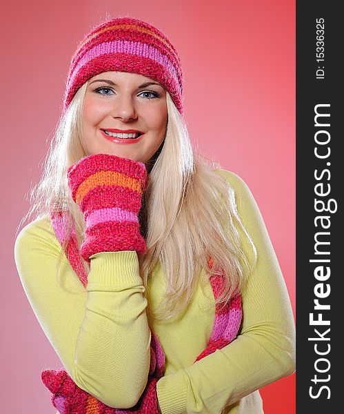 Seasonal portrait of pretty funny woman in hat and gloves smiling. pink background. Seasonal portrait of pretty funny woman in hat and gloves smiling. pink background