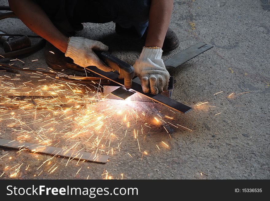 A worker is cutting metal sheet. A worker is cutting metal sheet.