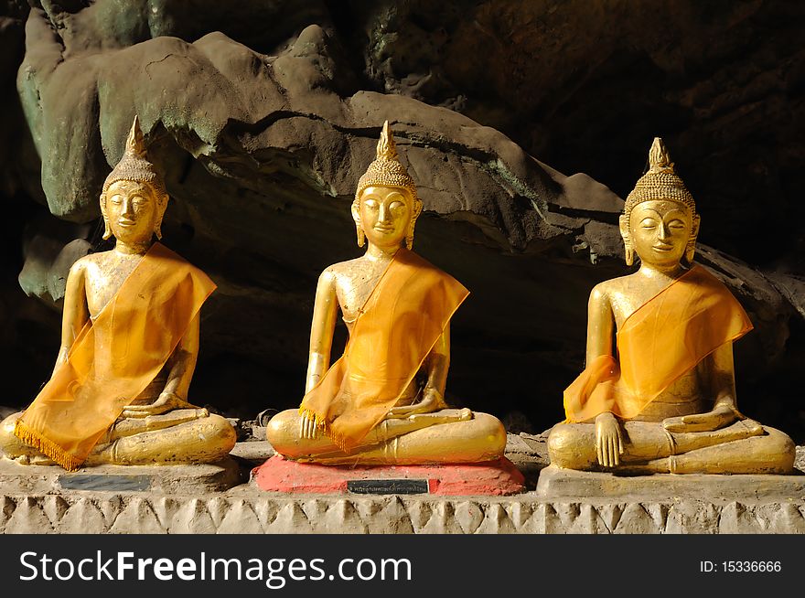 Three Buddha statue in cave.