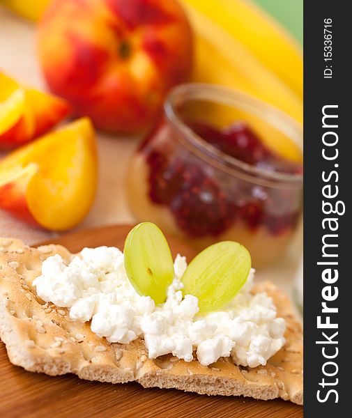 Fresh crispbread closeup with cottage cheese on a table with fruits