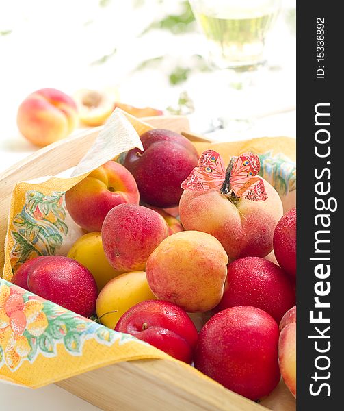 Fresh plums and apricots in bowl with butterfly. Fresh plums and apricots in bowl with butterfly