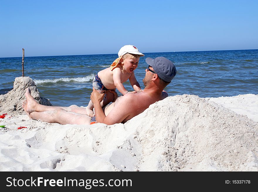 The father and son on the beach playing together