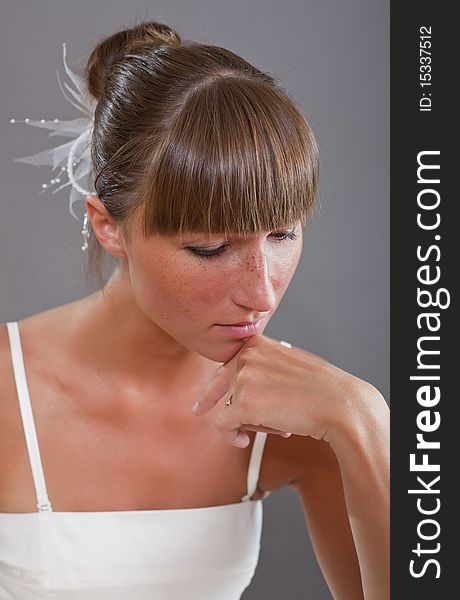 Portrait of sad bride over grey background