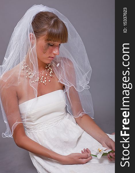 Disappointed and crying bride sitting on the ground