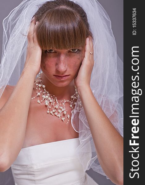 Frustrated bride holding her head with both hands