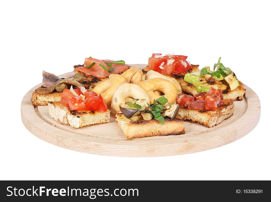 Typical italian appetizer: taralli and bruschetta (grilled bread rubbed with garlic and topped with various ingredients). Isolated on white. Typical italian appetizer: taralli and bruschetta (grilled bread rubbed with garlic and topped with various ingredients). Isolated on white