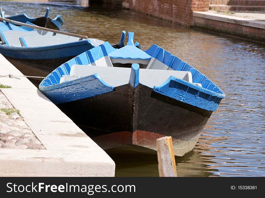 Wooden boats in a canal. Focus on the nearest boat. Shallow DOF.